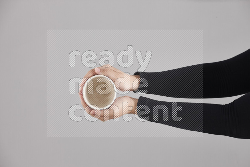 A woman in black abaya holding different pottery essentials in different positions
