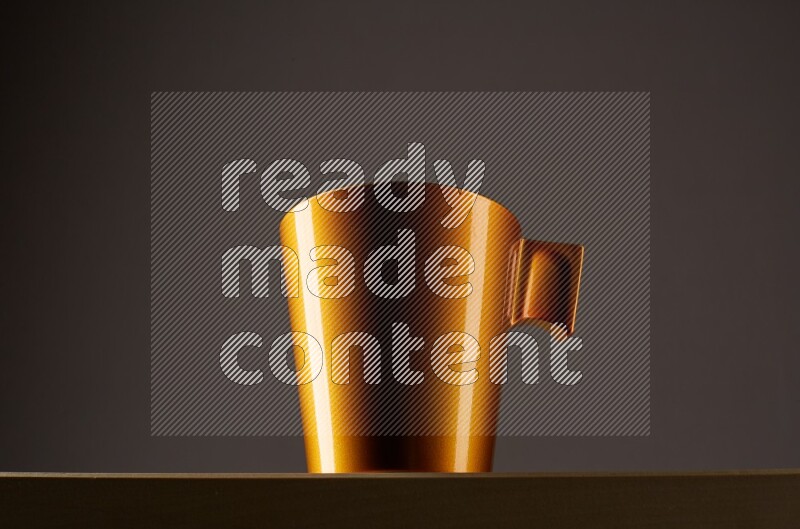 Low angle shot of a golden cup on grey background