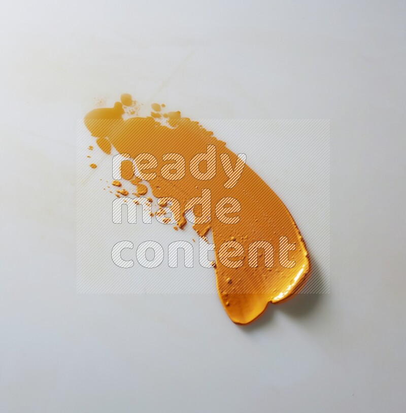 An orange single curved painting knife stroke on white background