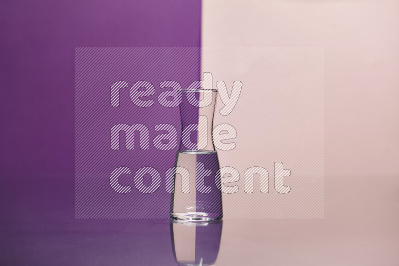 The image features a clear glassware filled with water, set against purple and rose background