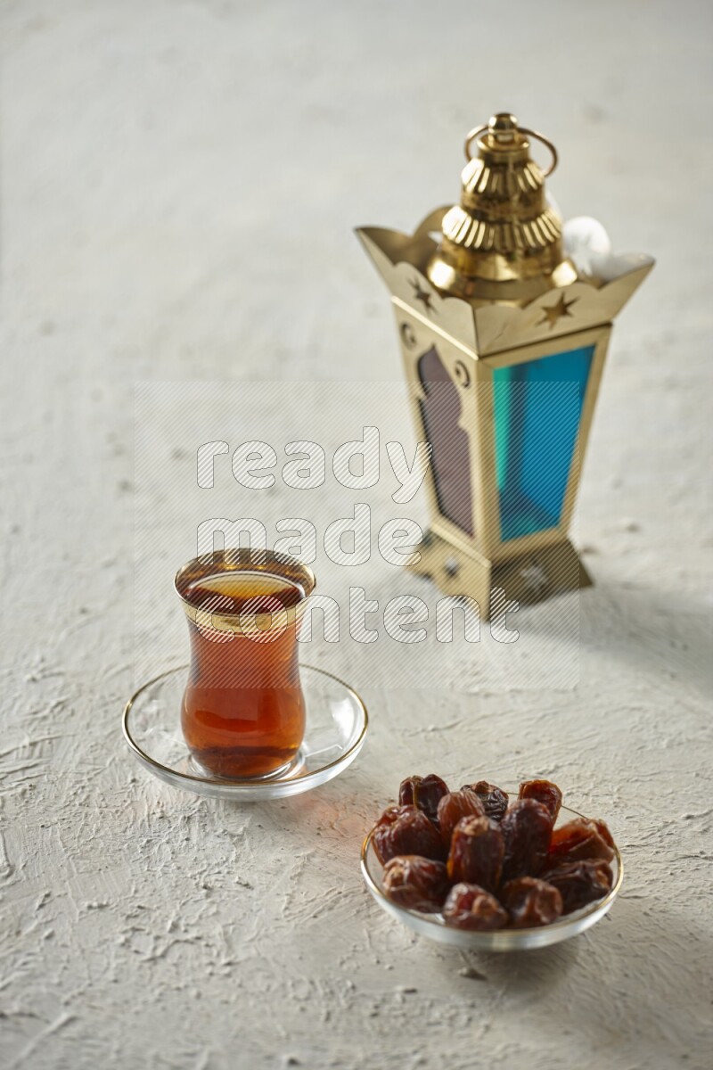 A golden lantern with different drinks, dates, nuts, prayer beads and quran on textured white background