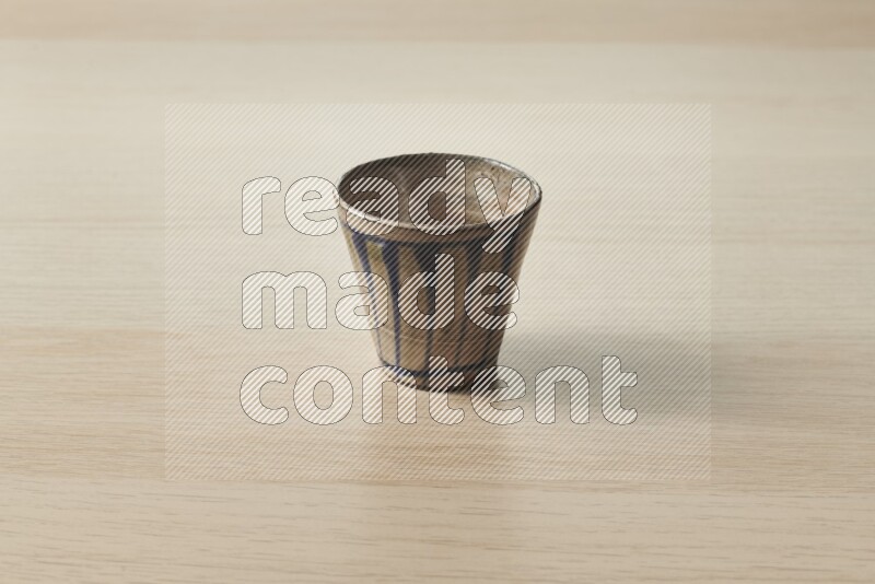 A pottery cup on light wooden background