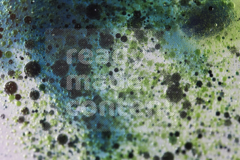 Close-ups of abstract green and blue watercolor drops on oil Surface on white background