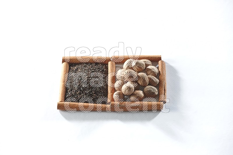 2 squares of cinnamon sticks full of black tea and nutmegs on white flooring