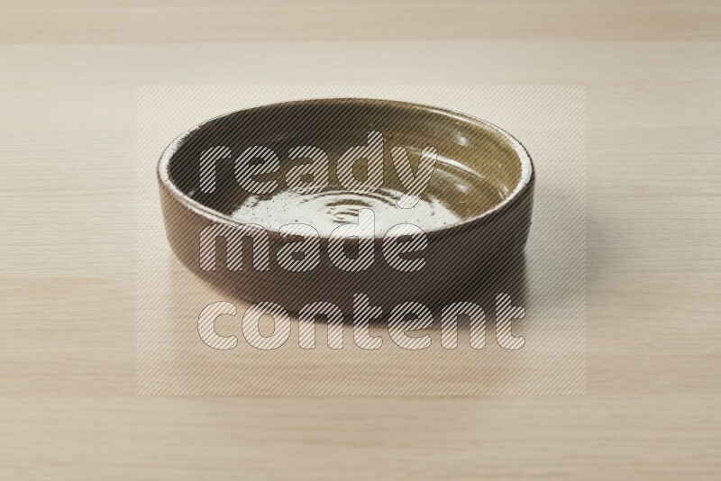 A multicolored pottery oven plate on light wooden background