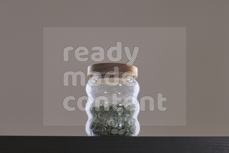 Buttons in a glass jar on black background