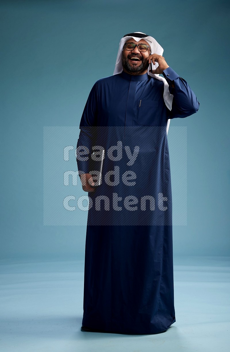 رجل سعودي يرتدي ثوب وشماغ يتحدث بالجوال