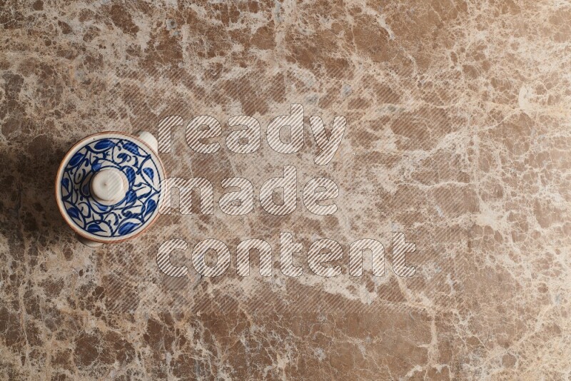 A multicolored pottery pot on beige marble background