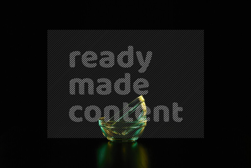 Glassware with rim light in green and yellow against black background