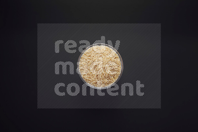 Vermicelli pasta in a glass bowl on black background