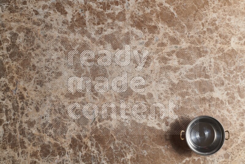 A small copper pot on beige marble background