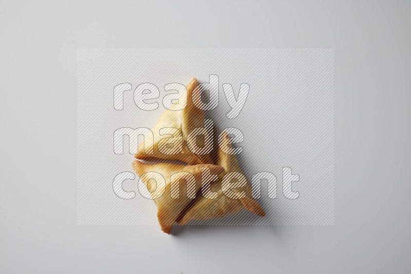 Three fried sambosa from a top angle on a white background