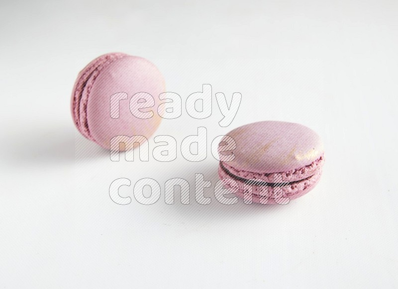 45º Shot of two Purple Strawberry macarons on white background