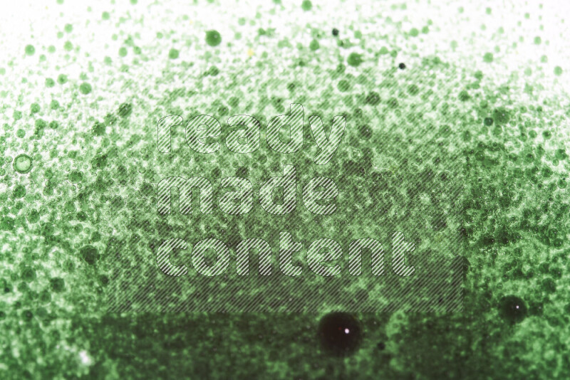 Close-ups of abstract green watercolor drops on oil Surface on white background