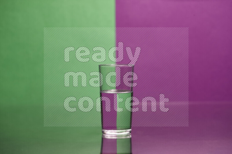 The image features a clear glassware filled with water, set against green and purple background