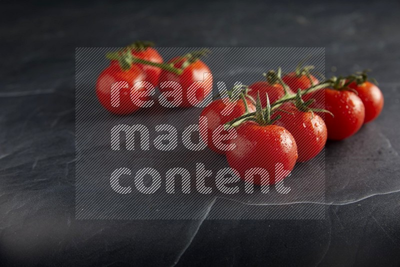 Red cherry tomato vein on a textured black slate background 45 degree