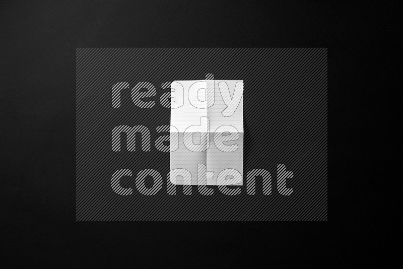 Folded notebook sheet on black background