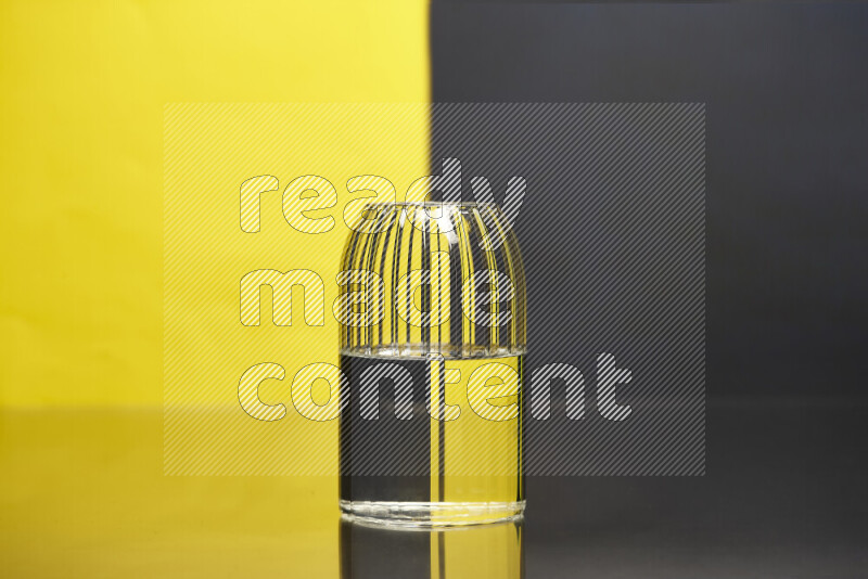 The image features a clear glassware filled with water, set against yellow and black background