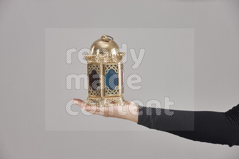 امرأة ترتدي عباءة سوداء تحمل فوانيس رمضانية مختلفة في أوضاع متعددة