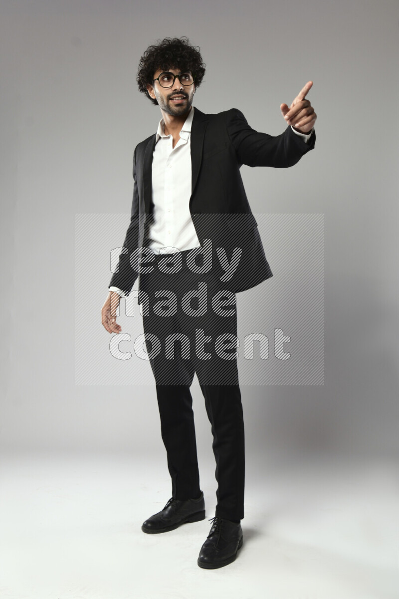 A man wearing formal standing and making a hand gesture on white background