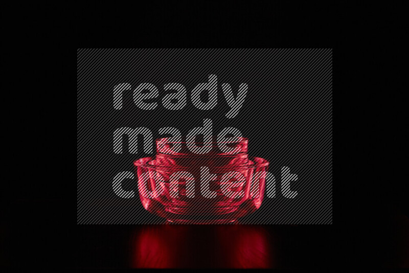 Glassware with rim light in red against black background