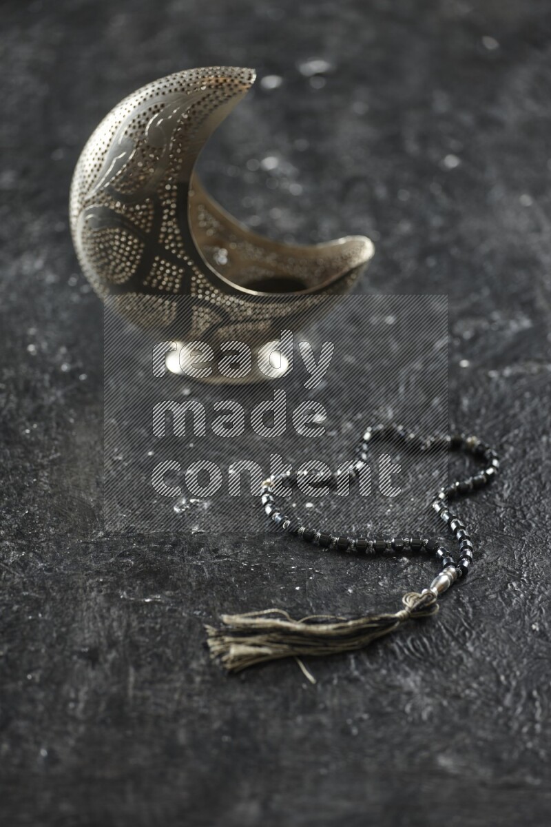 فانوس فضي مع مشروبات مختلفة وتمر ومكسرات وسبحة صلاة وقرآن على خلفية سوداء