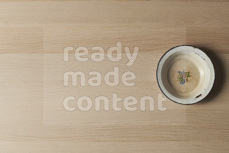 صحن معدني عتيق على خلفية خشبية فاتحة