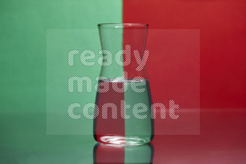 The image features a clear glassware filled with water, set against green and red background