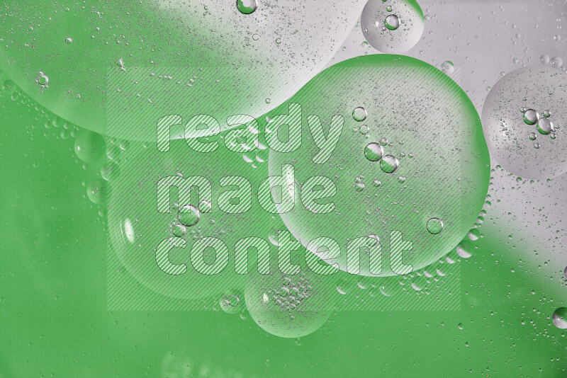 Close-ups of abstract oil bubbles on water surface in shades of white and green