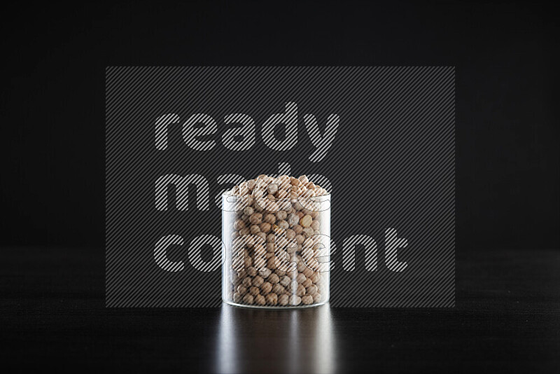 Chickpeas in a glass jar on black background