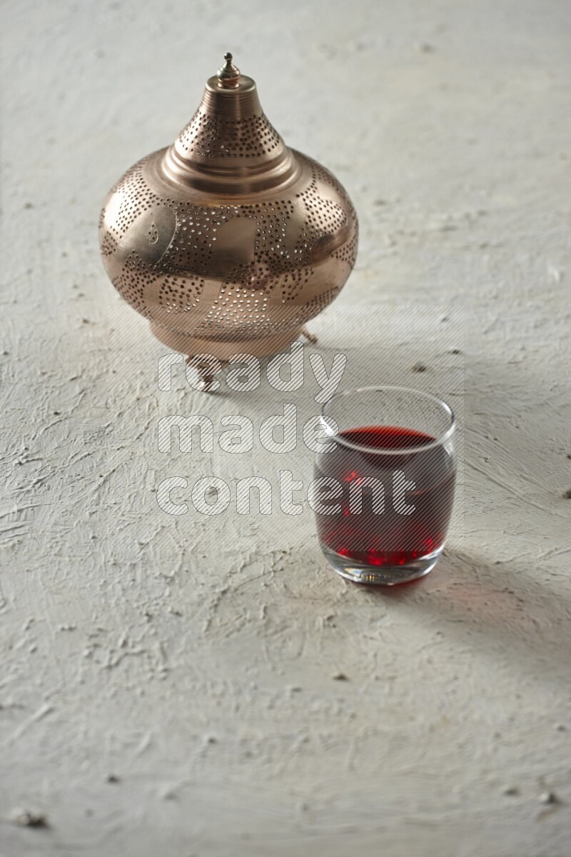 A golden lantern with different drinks, dates, nuts, prayer beads and quran on textured white background