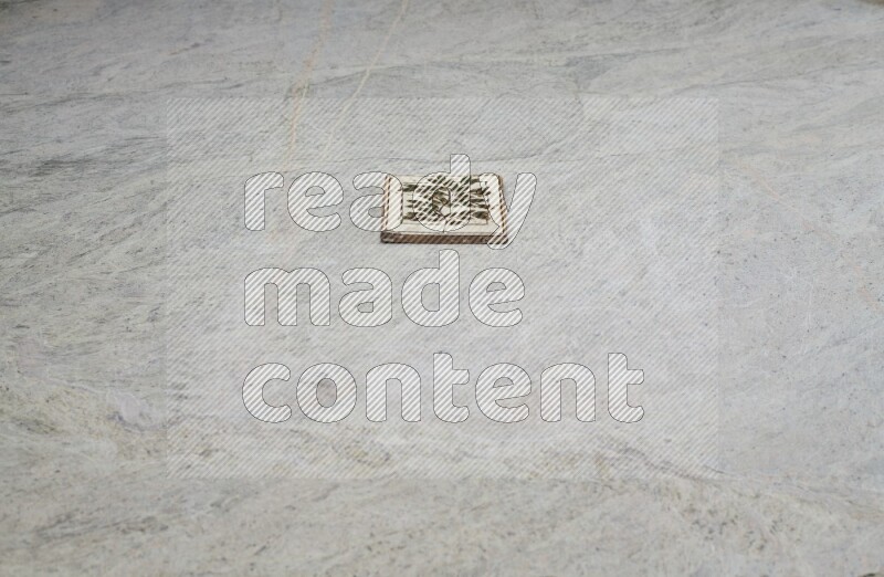 Top view shot of a pottery coaster\ tile on beige marble flooring