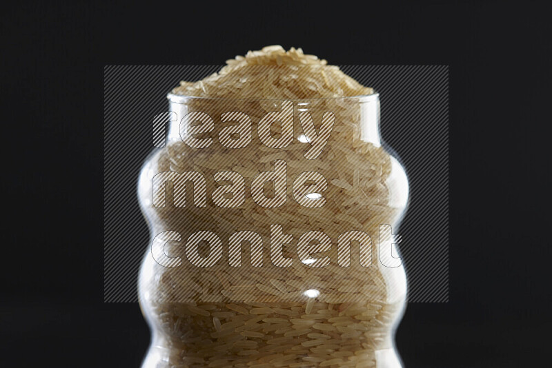 أرز بسمتي في وعاء زجاجي على خلفية سوداء