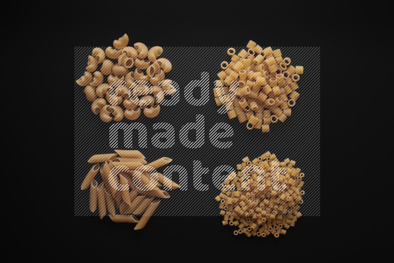 Different pasta types in bunches on black background