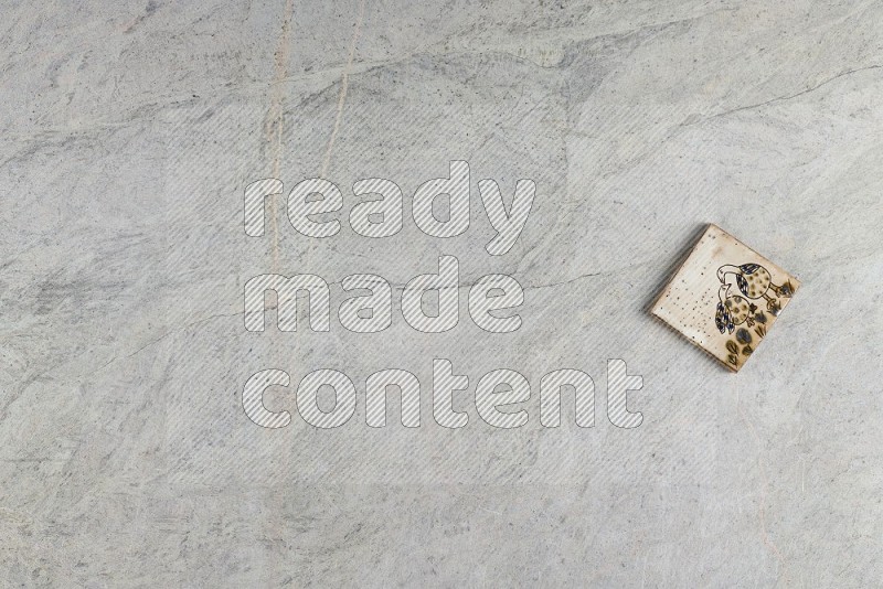 Top View Shot Of A Pottery Coaster tile On Grey Marble Flooring