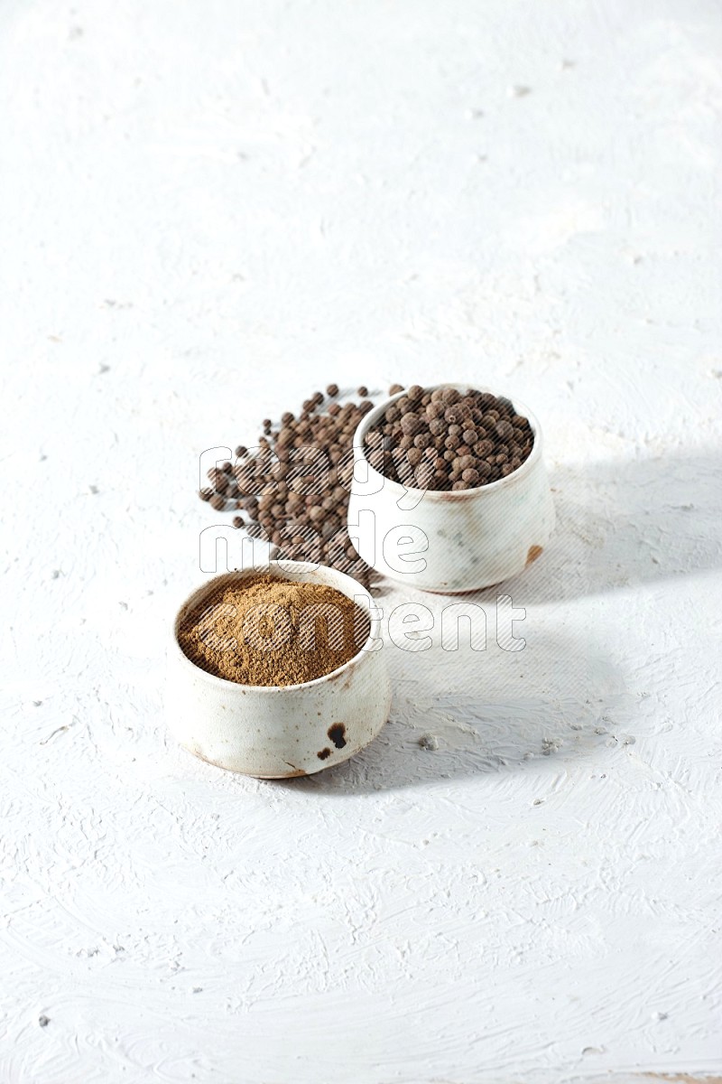 2 beige bowls, one full of powder and the other full of whole balls with balls and powder spreaded on a textured white flooring