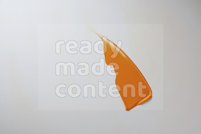 An orange single curved painting knife stroke on white background
