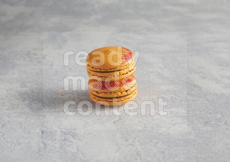 45º Shot of two orange Exotic macarons on white  marble background