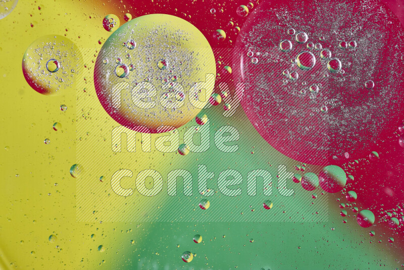 Close-ups of abstract oil bubbles on water surface in shades of yellow, green and red