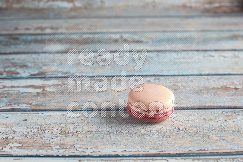 45º Shot of Pink Litchi Raspberry macaron on light blue wooden background