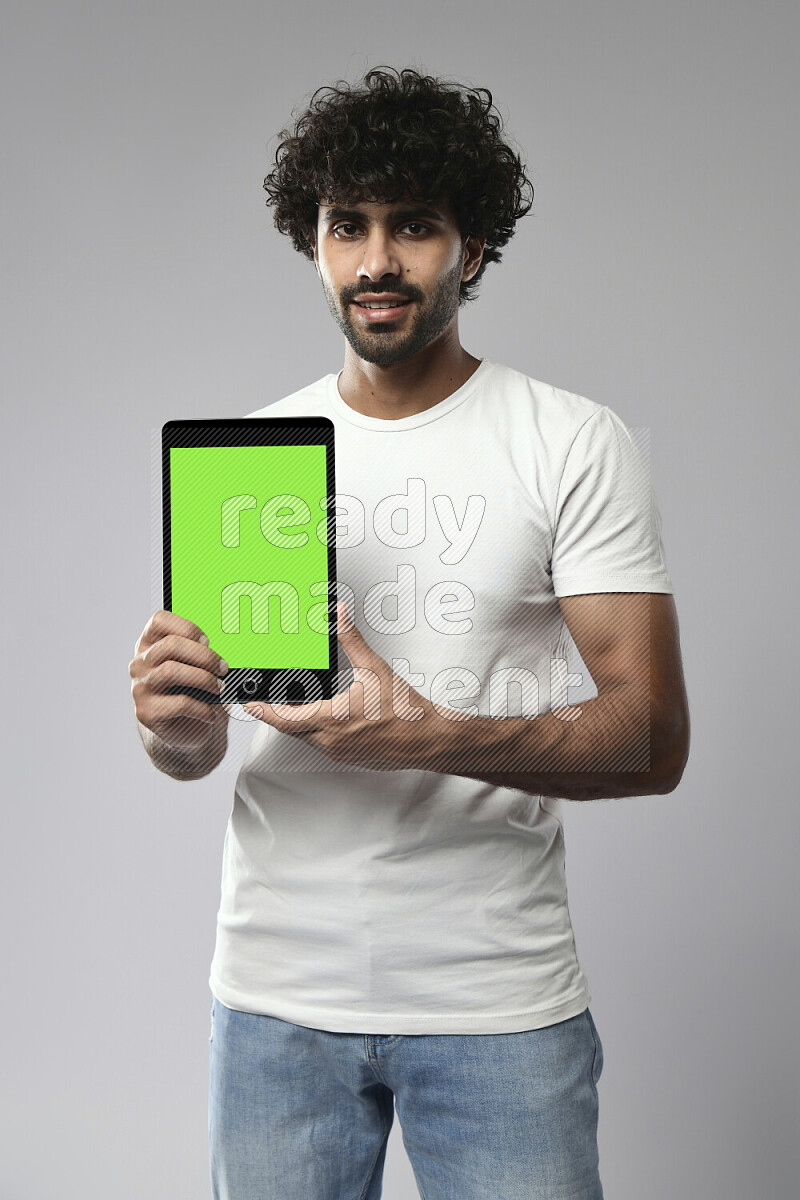 A man wearing casual standing and showing a tablet screen on white background