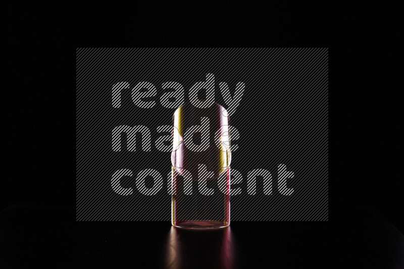 Glassware with rim light in red and yellow against black background