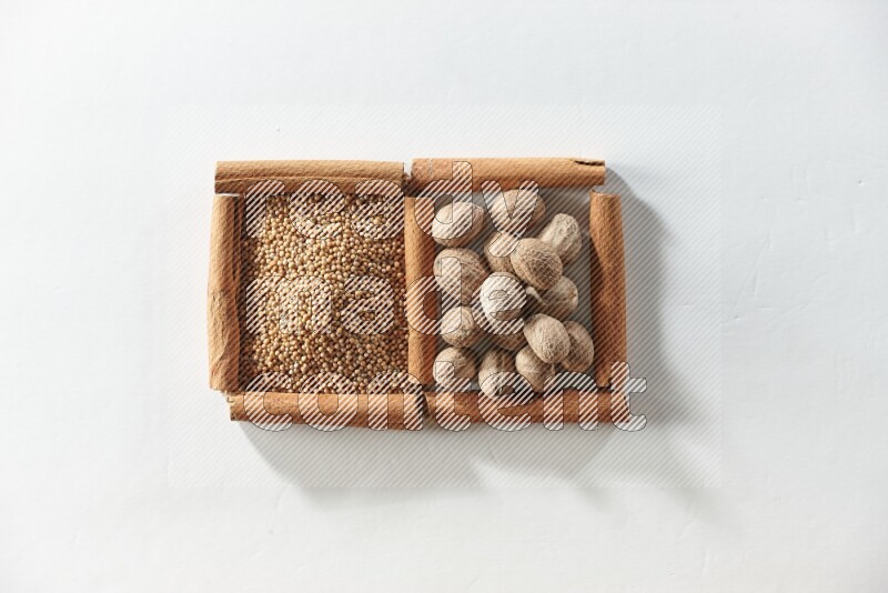 2 squares of cinnamon sticks full of mustard seeds and nutmegs on white flooring