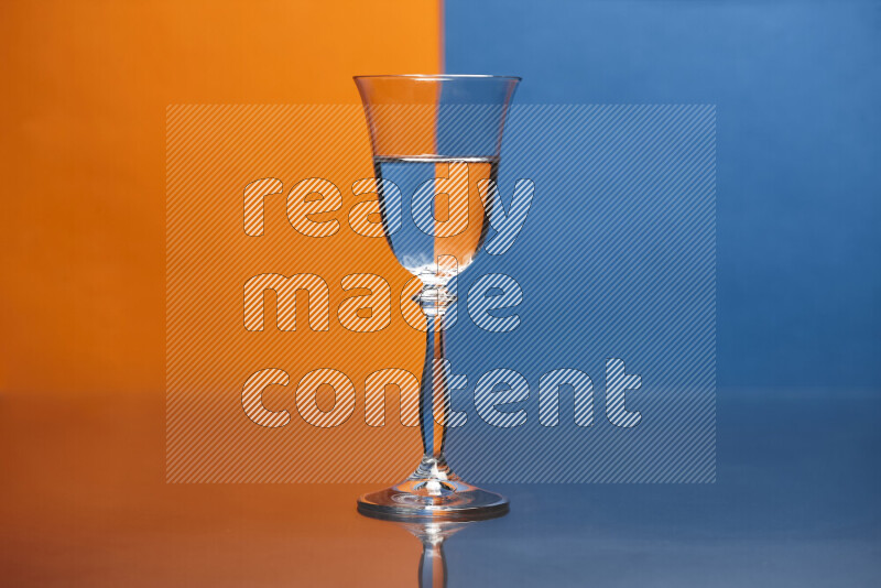 The image features a clear glassware filled with water, set against orange and blue background