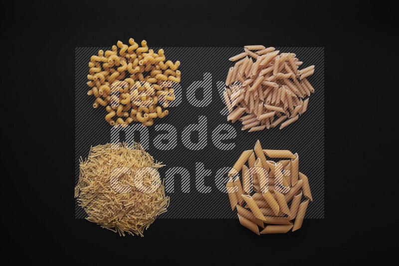 Different pasta types in bunches on black background