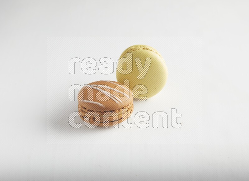45º Shot of of two assorted Brown Irish Cream, and Yellow Lime macarons on white background