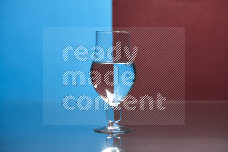 The image features a clear glassware filled with water, set against blue and dark red background