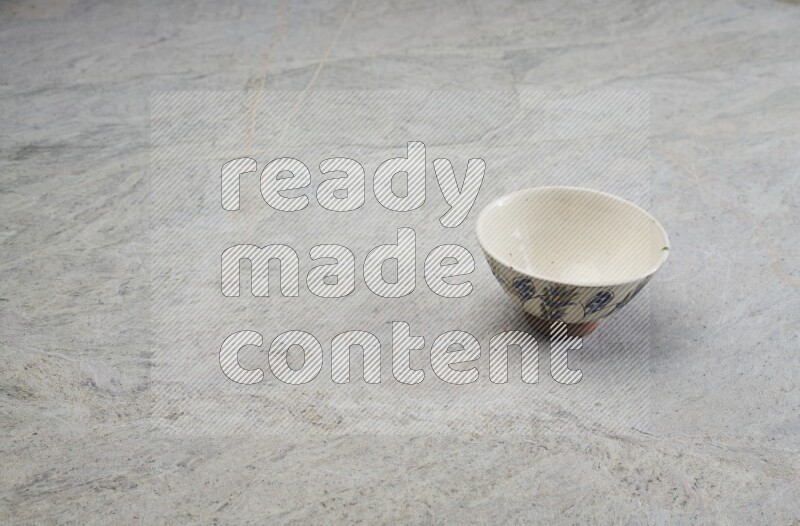 A multicolored pottery bowl on grey marble background