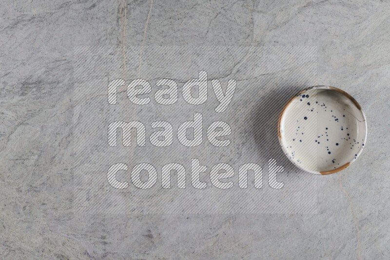 وعاء فخاري متعدد الألوان على خلفية من الرخام الرمادي