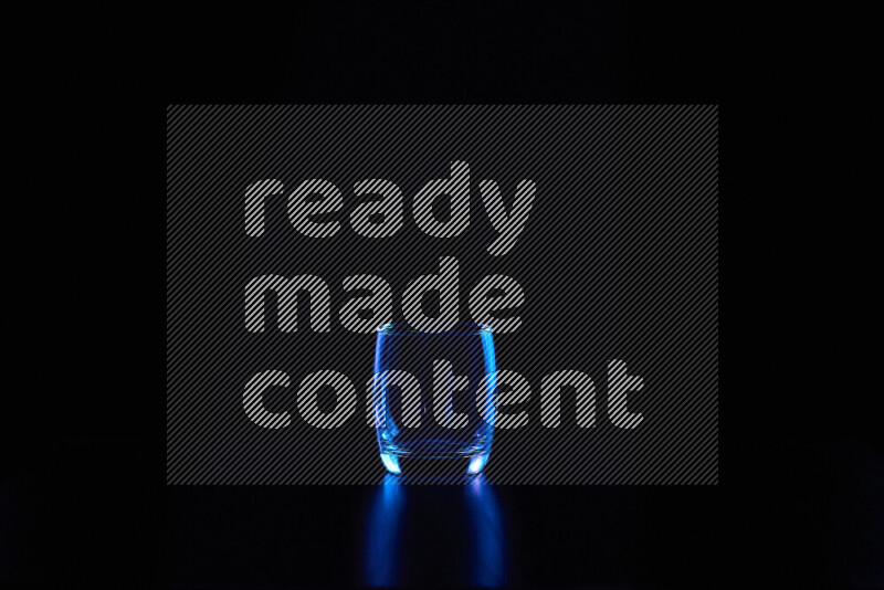 Glassware with rim light in blue against black background